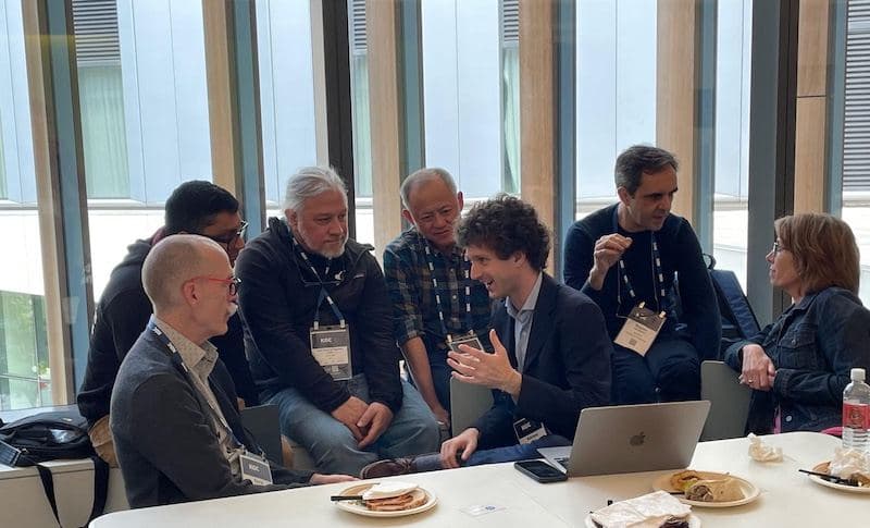 Attendees in a lively conversation around a table at KGC 2025