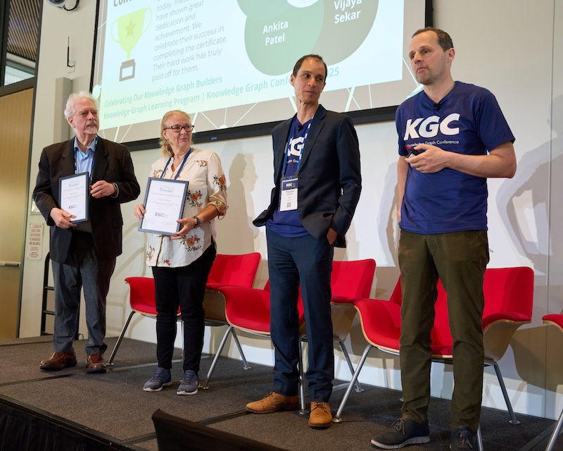 Builder Certificate graduates stand on stage to commemorate their completion of the Knowledge Graph Certificate Program